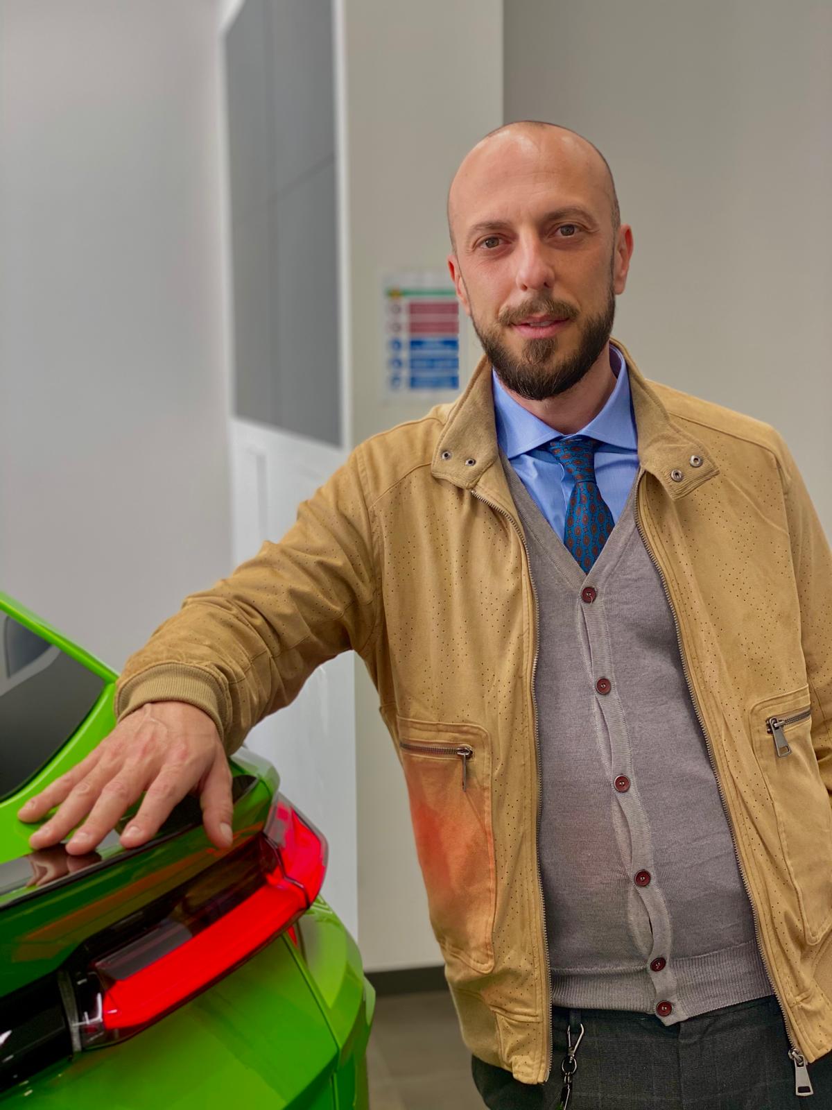 Federico Cappa giacca cammello accanto a Lamborghini Huracán verde showroom